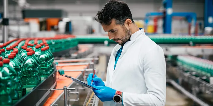 Ingénieur prenant des notes dans usines de contenants